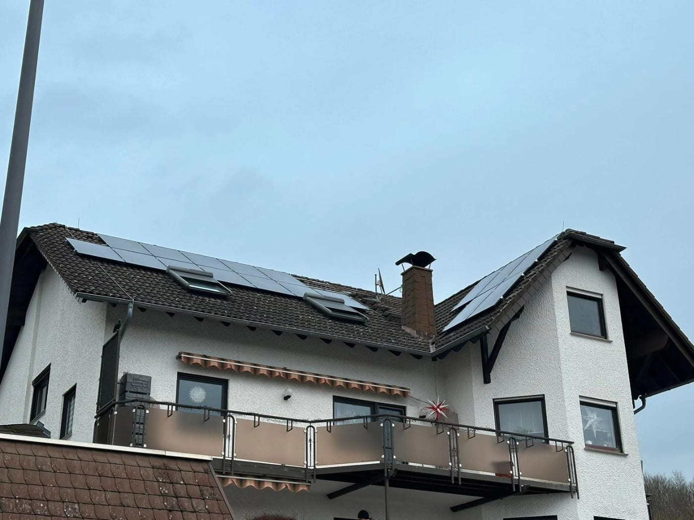 Wohnhaus mit Photovoltaikanlage und Dachfenstern auf dem Ziegeldach