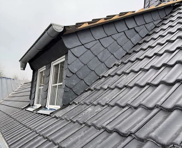 Detail einer schiefergedeckten Gaube mit Fenster und Ortgangblech