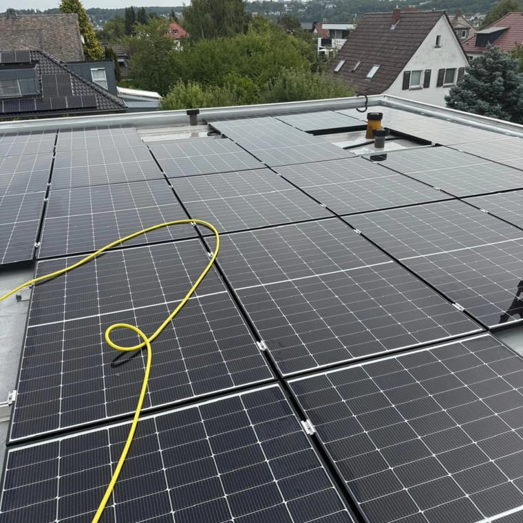 Photovoltaikmodule auf einem Flachdach mit Blick über den Ort