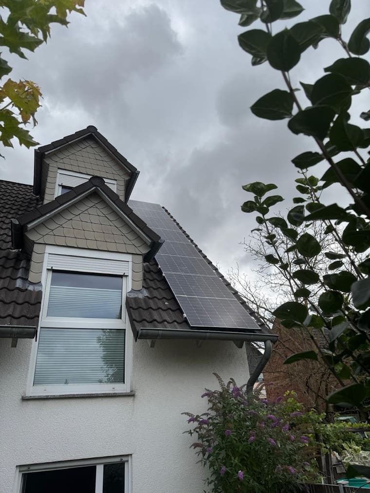 Wohnhaus mit Gaube und Photovoltaikanlage auf dem Ziegeldach