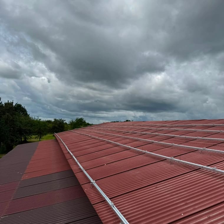 Rotes Trapezblechdach mit montierten Photovoltaik-Trageschienen